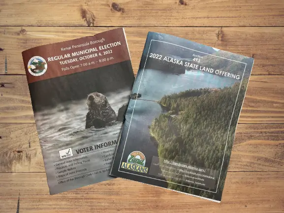 Municipal election voter information booklet and an Alaska land offering catalogue